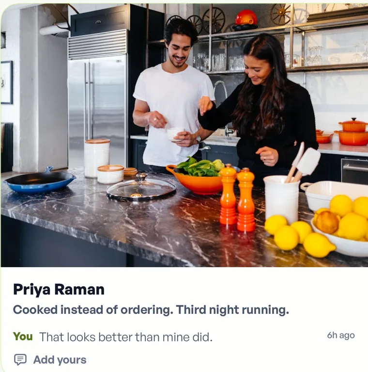 A photo card in Fika: two people cooking together, posted by Priya Raman with the note cooked instead of ordering, third night running, and a reply reading that looks better than mine did.